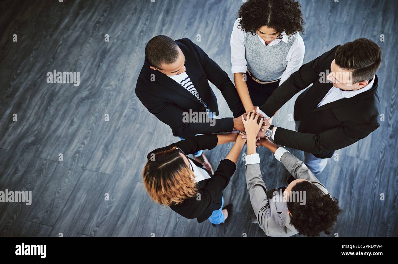 L'excellence est ce qui était après. Photo en grand angle d'un groupe d'hommes d'affaires qui se joignent à eux dans un caucus. Banque D'Images