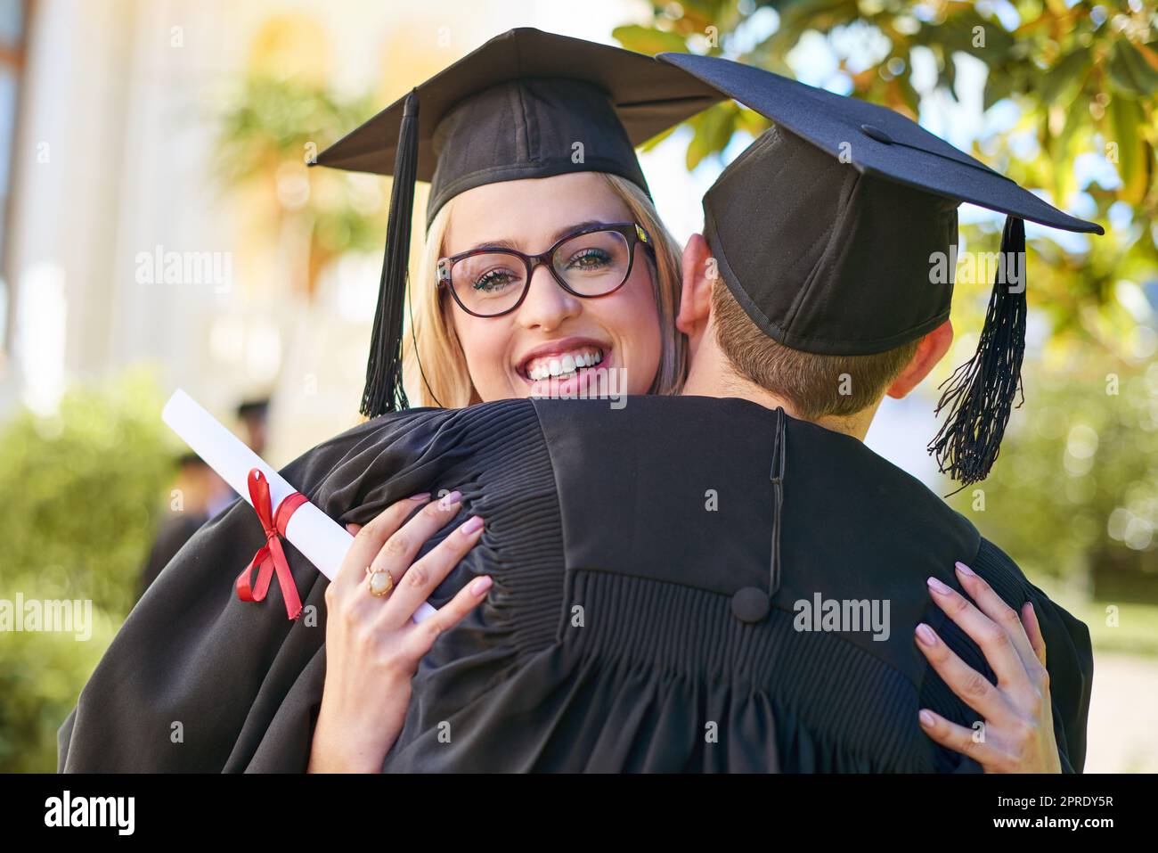 Le jour de la remise des diplômes est un jour de fête. Un jeune couple s'embrasse les uns les autres le jour de la remise des diplômes. Banque D'Images