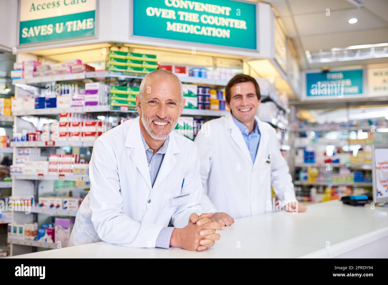 Étaient plus qu'heureux de répondre à vos besoins en matière de soins de santé. Portrait de deux pharmaciens de sexe masculin travaillant dans un chimiste. Banque D'Images
