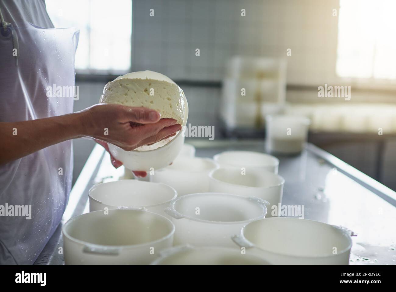 Fromage fait à la main. Une travailleuse agricole méconnue qui fabrique du fromage dans une usine de la ferme. Banque D'Images