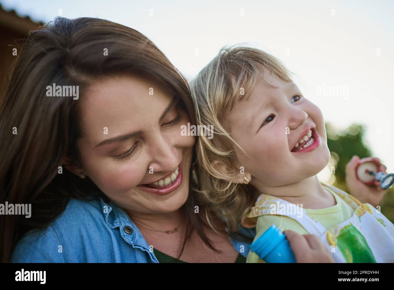 Prenez le temps de vous amuser avec vos enfants. Une mère et sa petite fille soufflent des bulles à l'extérieur. Banque D'Images