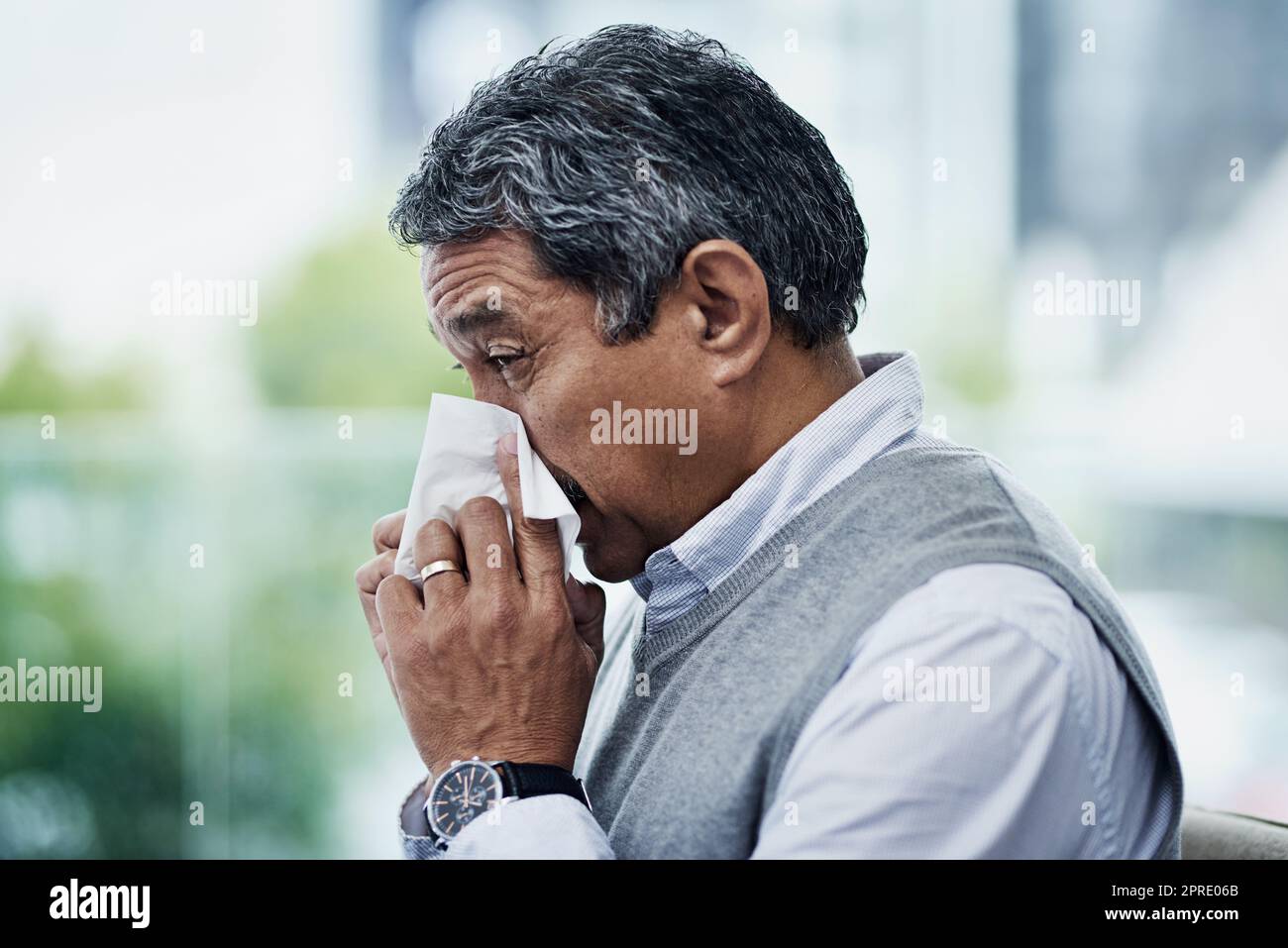 La saison de la grippe est une fois de plus sur nous. Un homme mûr soufflant son nez. Banque D'Images