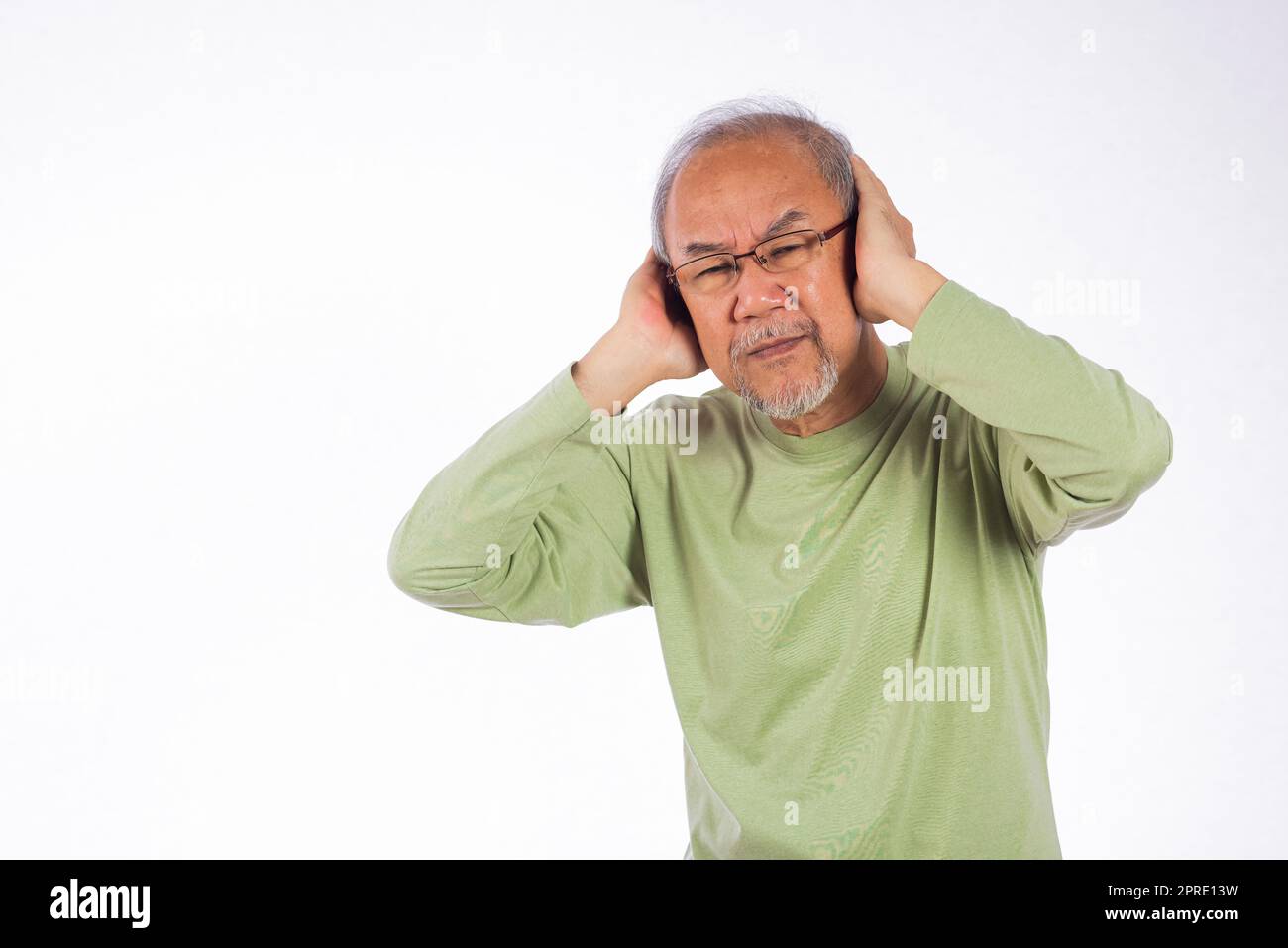 Portrait d'un vieil homme âgé avec des lunettes triste couvrant les oreilles avec les doigts mains Banque D'Images