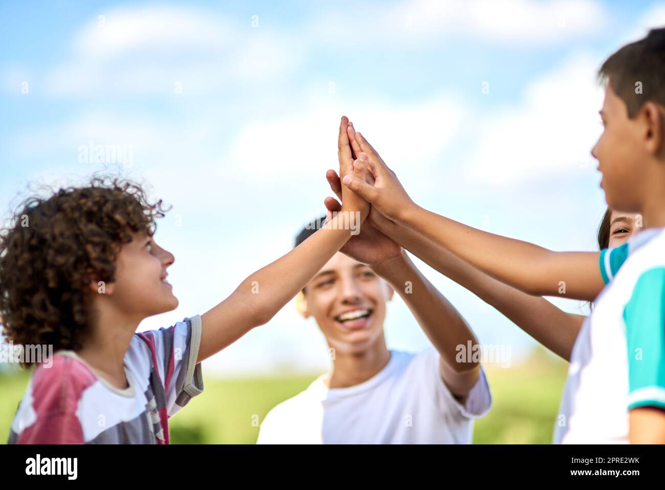 Vous pouvez toujours compter sur les frères et sœurs pour vous garder motivé. Un groupe de frères et sœurs heureux se donnant un haut cinq dehors. Banque D'Images