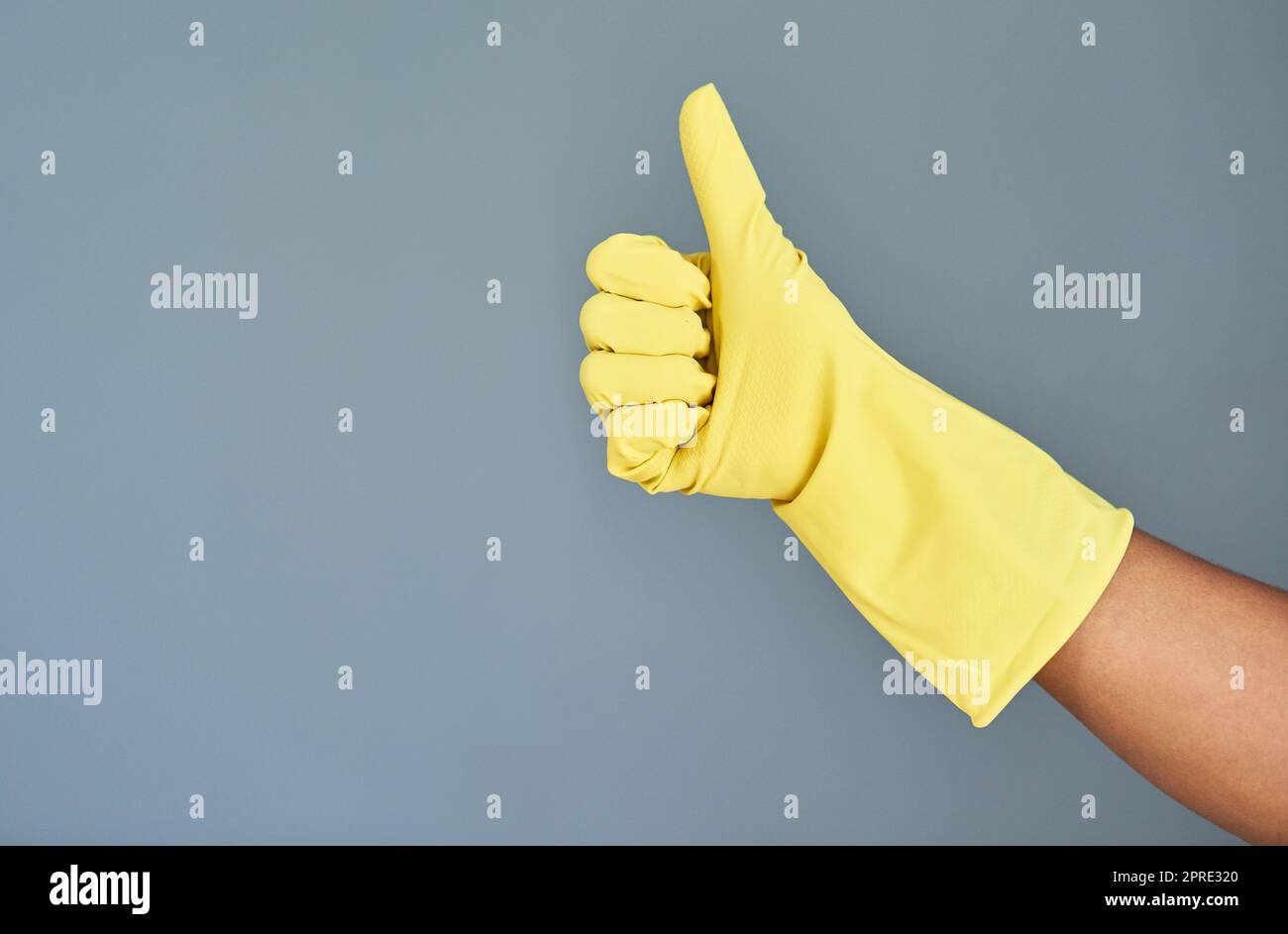 Bravo pour une maison propre. Photo en studio d'une femme méconnaissable portant des gants en caoutchouc montrant les pouces sur un fond gris. Banque D'Images