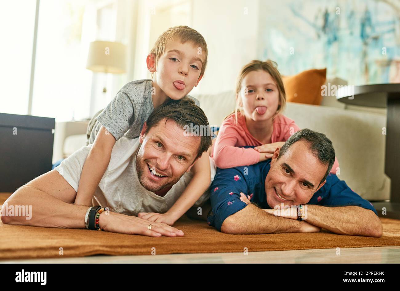 Theres toujours temps pour la famille. Portrait complet d'une famille affectueuse de quatre personnes, couché sur le sol de leur salon. Banque D'Images