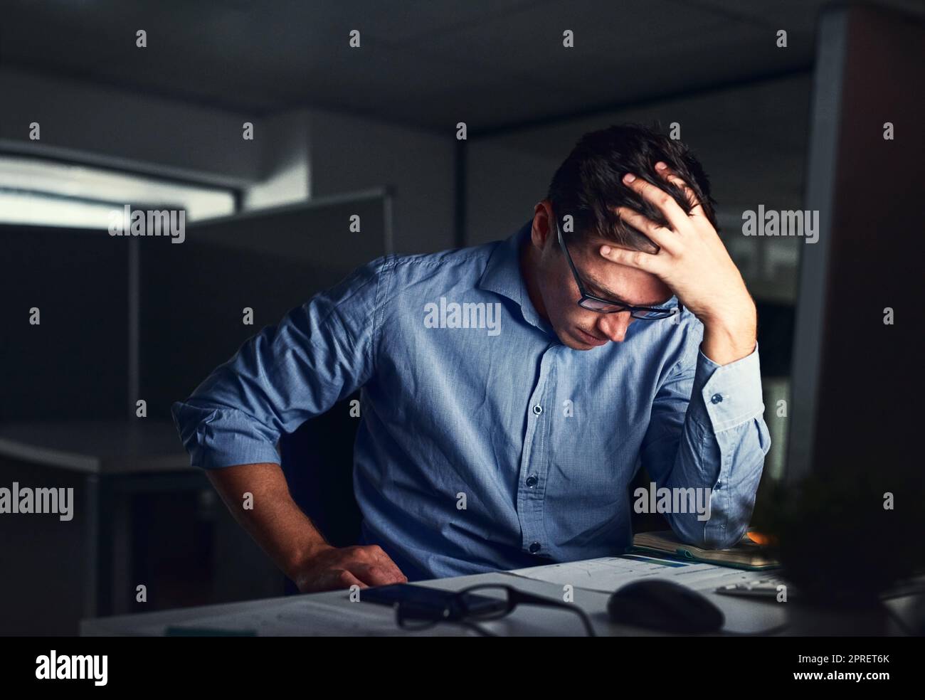 Homme d'affaires stressé et fatigué souffrant de maux de tête, travaillant tard dans la nuit au bureau. Inquiet entrepreneur homme pensant à des problèmes et à l'échéance du projet sentiment d'épuisement, de détresse et d'épuisement. Banque D'Images