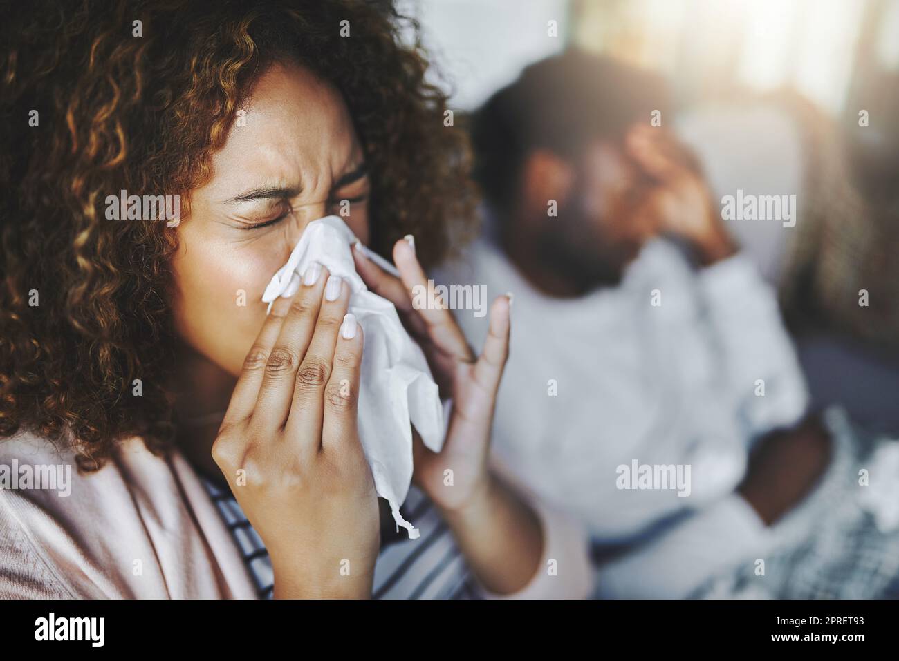 Femme malade ou malade souffrant d'allergie, d'infection sinusale éternuant dans les tissus ou soufflant le nez pendant la saison de la grippe à la maison. Une fille malade a attrapé un mauvais rhume montrant des symptômes de covid, ou souffrant d'une maladie virale Banque D'Images