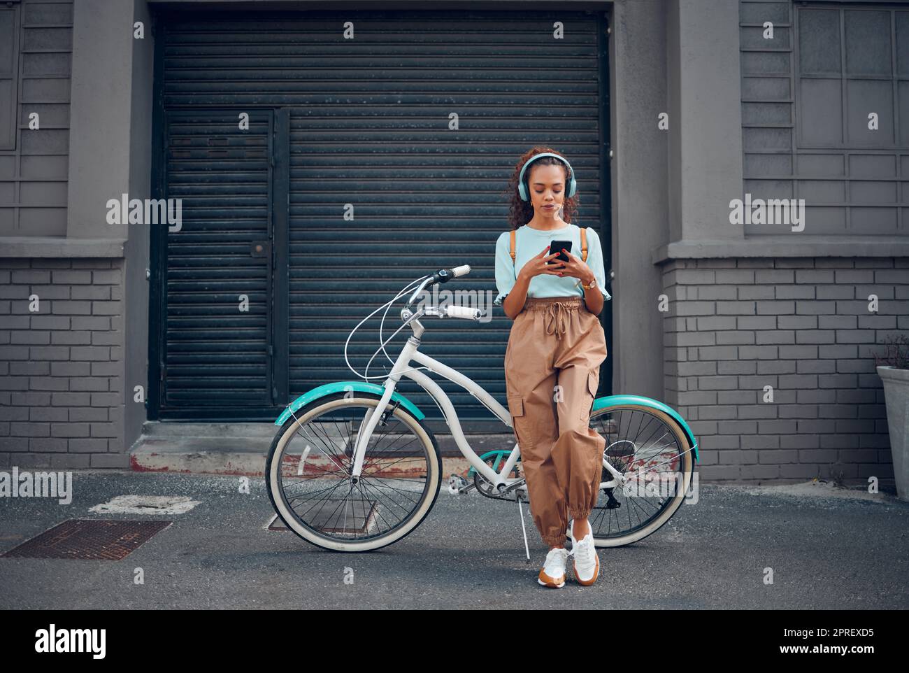 Casque, femme et téléphone avec vélo dans la ville écouter de la musique ou  balado en plein air en été avec un look tendance. Transport écologique  Photo Stock - Alamy