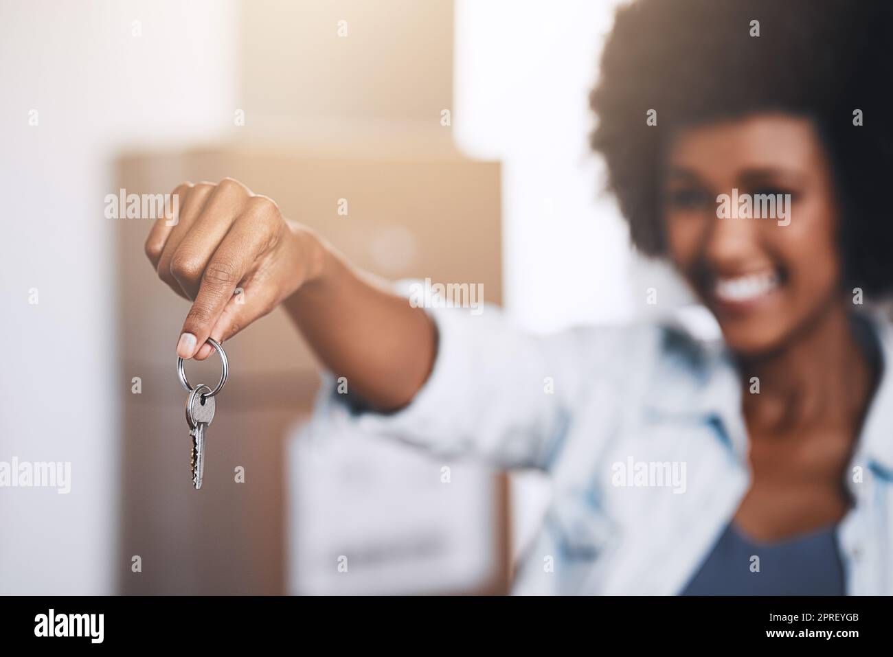 Sa nouvelle vie commence. Une jeune femme tenant les clés de sa maison dans sa nouvelle maison. Banque D'Images