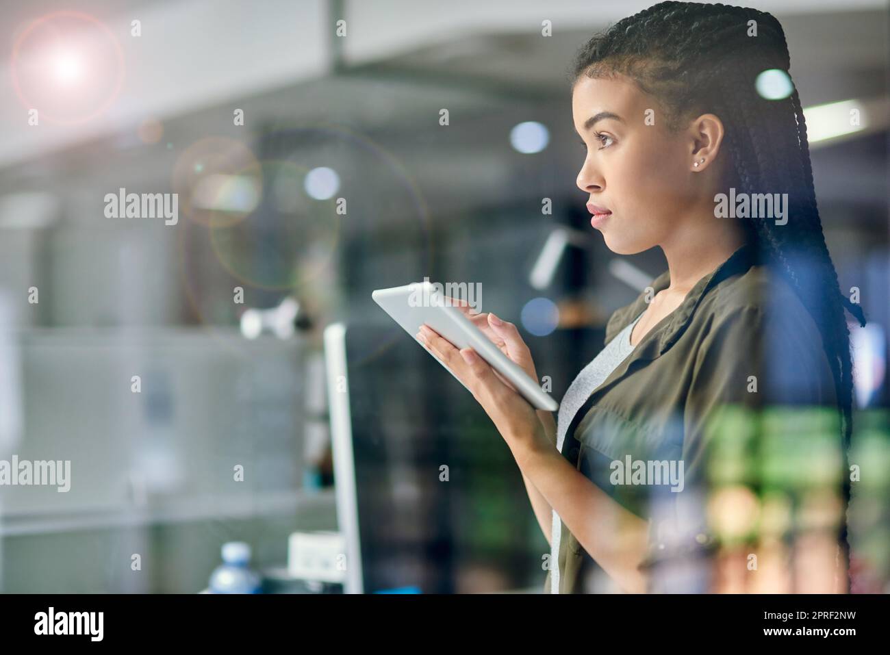 Tout droit aux affaires. Une jeune femme d'affaires utilisant une tablette au bureau. Banque D'Images