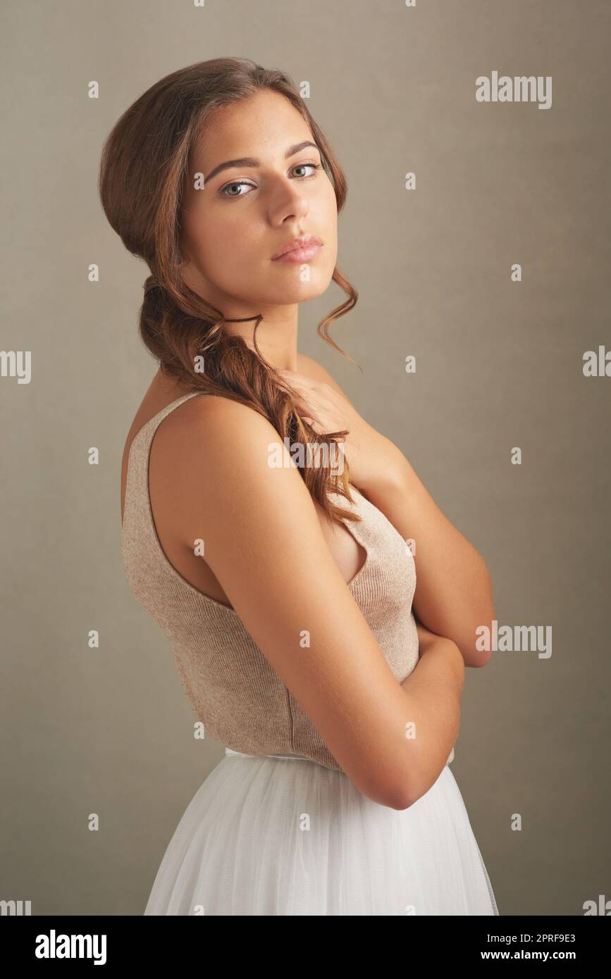 Shes plus qu'un joli visage. Photo en studio d'une jeune femme attrayante posant sur un fond marron. Banque D'Images