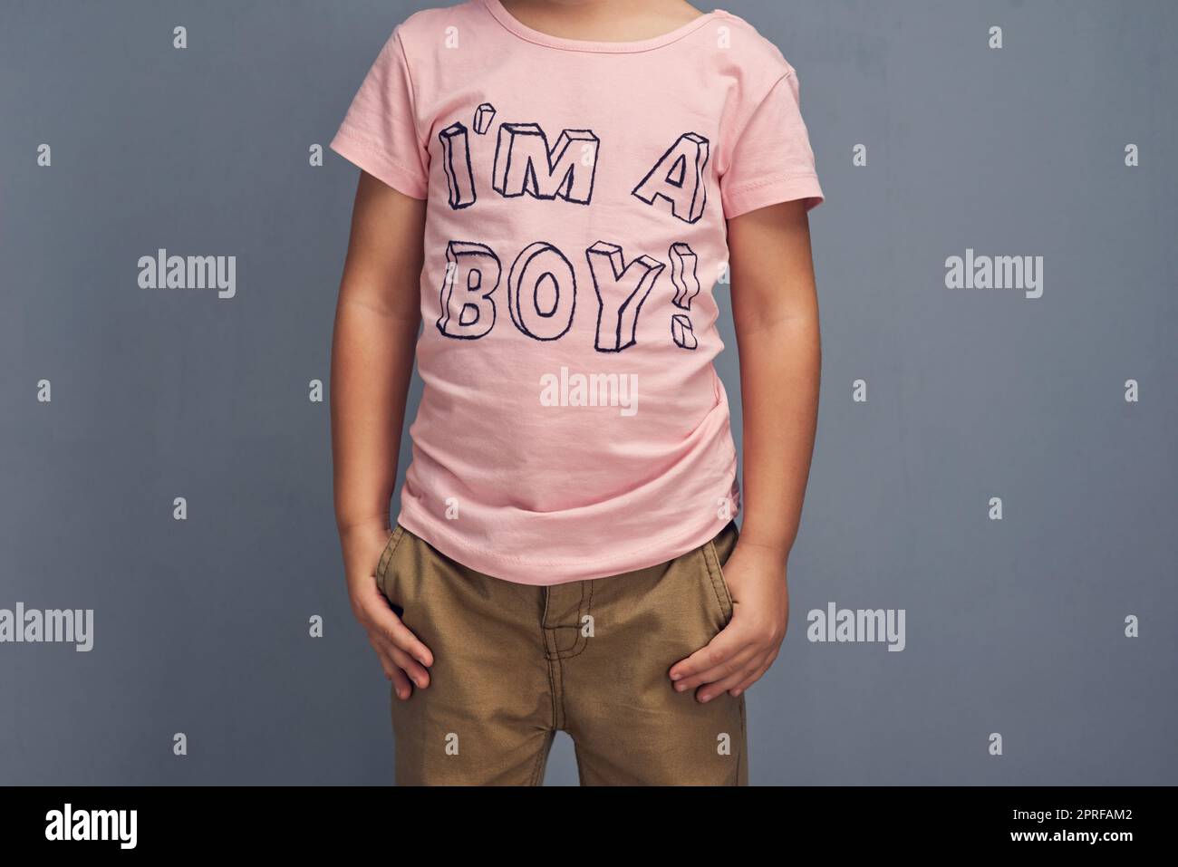 Le rose est une couleur, pas un sexe. Photo studio d'un garçon portant une t-shirt avec IM un garçon imprimé sur un fond gris. Banque D'Images