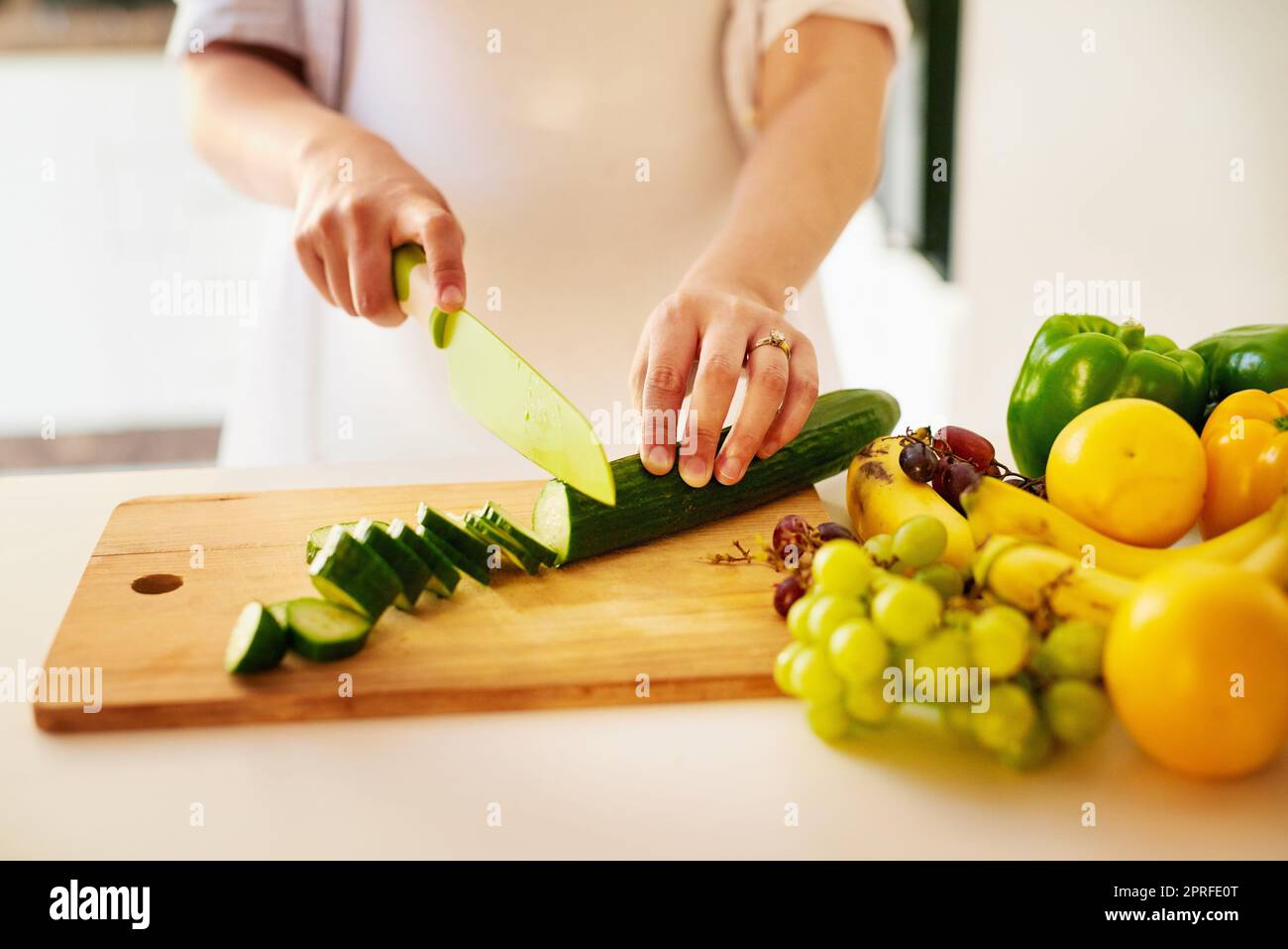 Je mange en bonne santé pour nous deux. Une femme enceinte méconnaissable hacher des fruits et des légumes à la maison. Banque D'Images