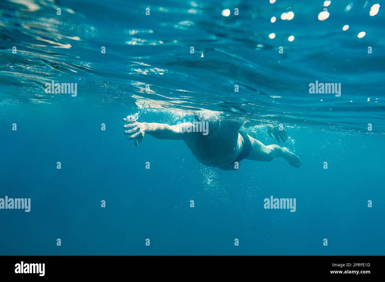L'homme sportif nage rapidement dans la mer Banque D'Images