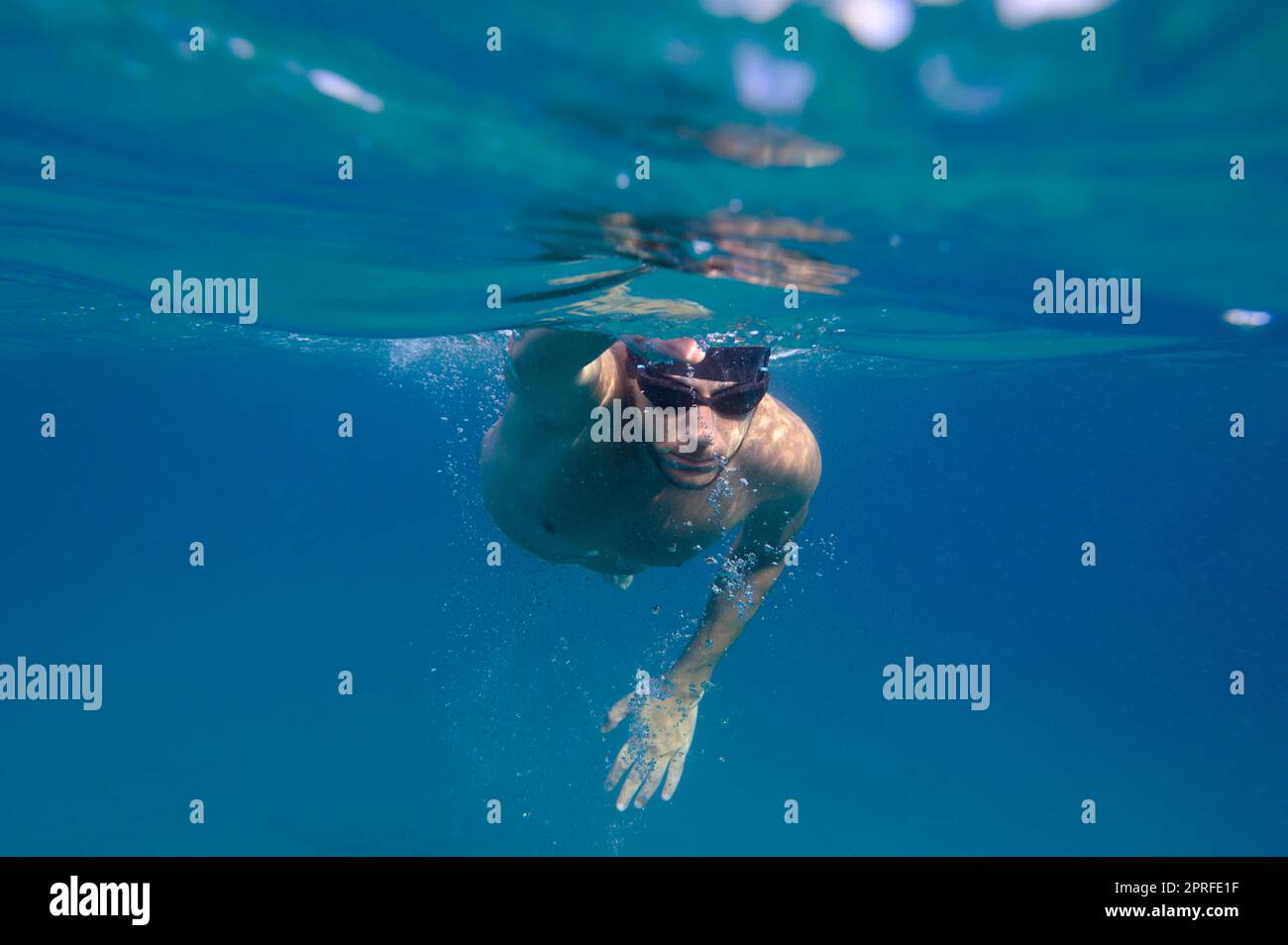 L'homme sportif nage rapidement dans la mer Banque D'Images