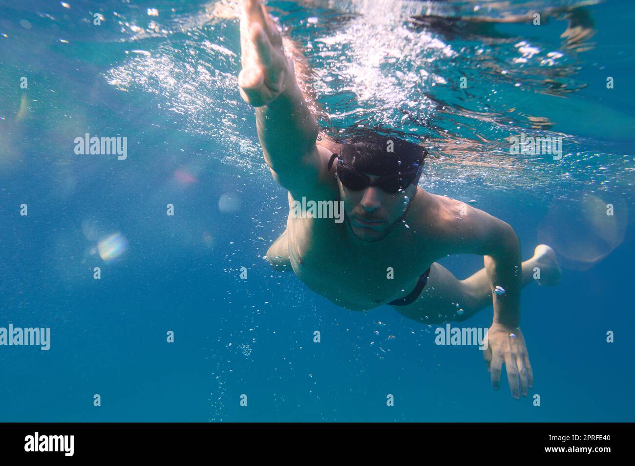 L'homme sportif nage rapidement dans la mer Banque D'Images