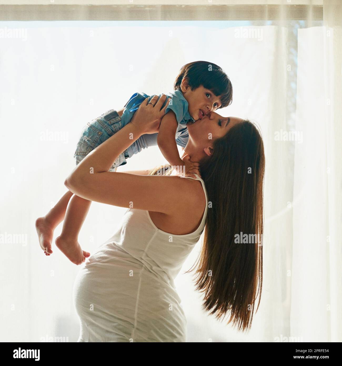 Maman vous aime à la lune et au dos. Une femme enceinte jouant avec son petit garçon dans sa chambre à la maison. Banque D'Images