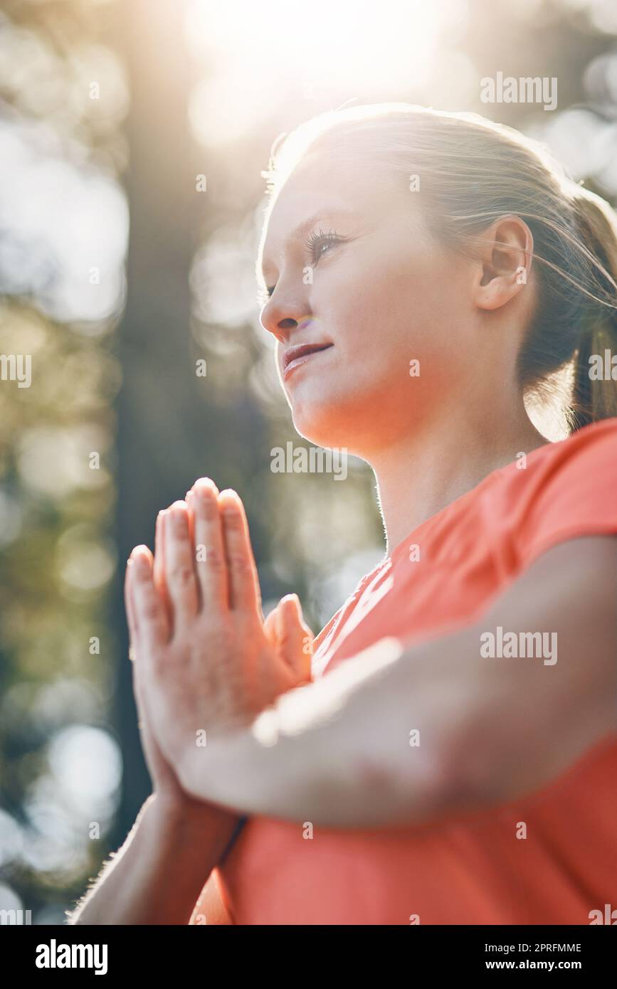 Calmer l'esprit et écouter votre corps. Une jeune femme avec les mains de prière dehors. Banque D'Images