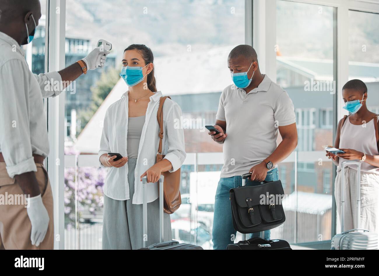 Covid, travailleur des voyages et de la santé qui teste la température des personnes à bord d'un vol à l'aéroport. Une infirmière, la santé et la sécurité avec des voyageurs dans des masques faisant l'objet d'un test de corona pour monter dans un avion. Banque D'Images