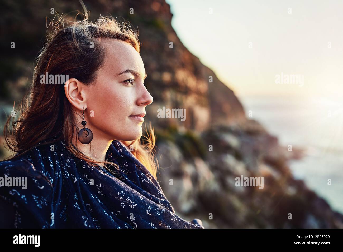 Perdu dans la pensée à la mer. Une jeune femme attrayante appréciant un certain temps dehors. Banque D'Images