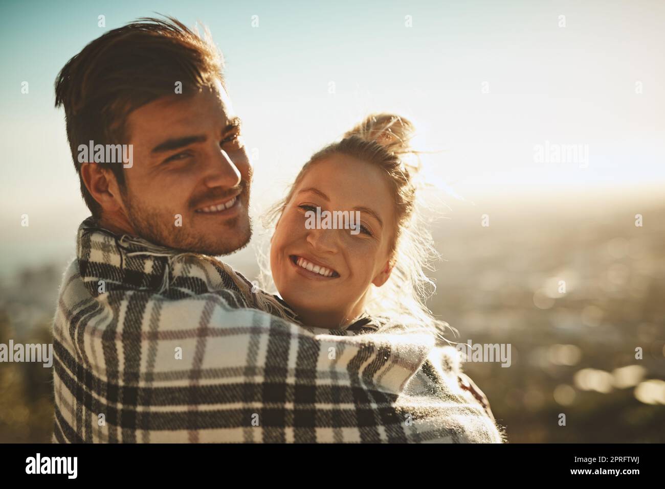 Un couple affectueux enveloppé d'une couverture tout en passant du temps dans la nature. Banque D'Images