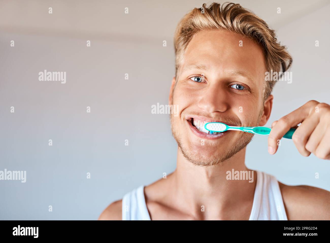 L'hygiène dentaire est de la plus haute importance. Portrait d'un jeune homme se brossant les dents à la maison. Banque D'Images