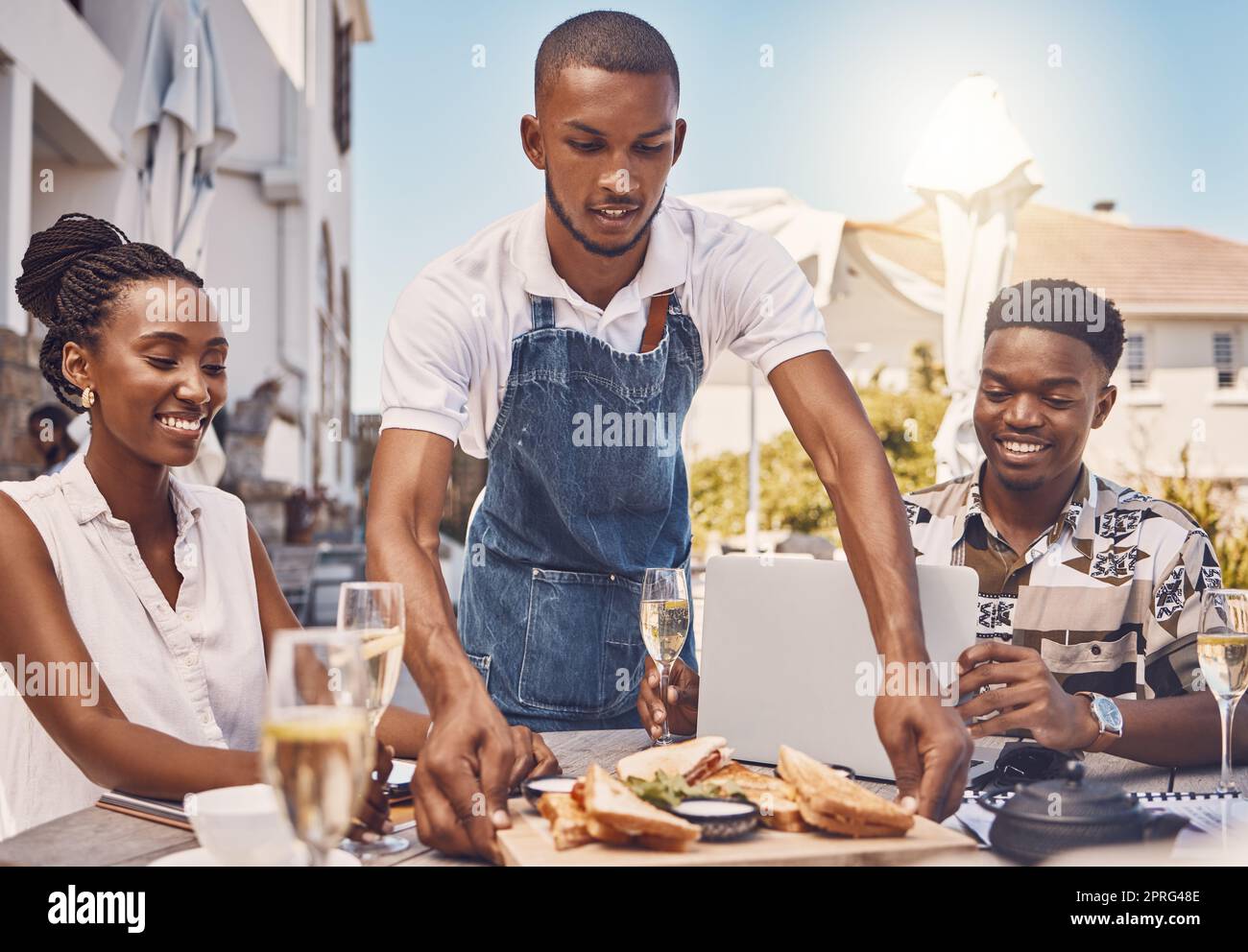 Serveur servant de la nourriture pour couple dans un restaurant, travailleur donnant le service et la nourriture sur table dans un café en été. Un homme et une femme heureux qui mangent le déjeuner dans un magasin, heureux avec le serveur et la date au café-restaurant Banque D'Images