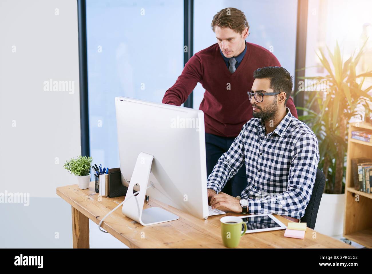 En lui donnant quelques conseils. Des hommes d'affaires créatifs travaillant au bureau. Banque D'Images