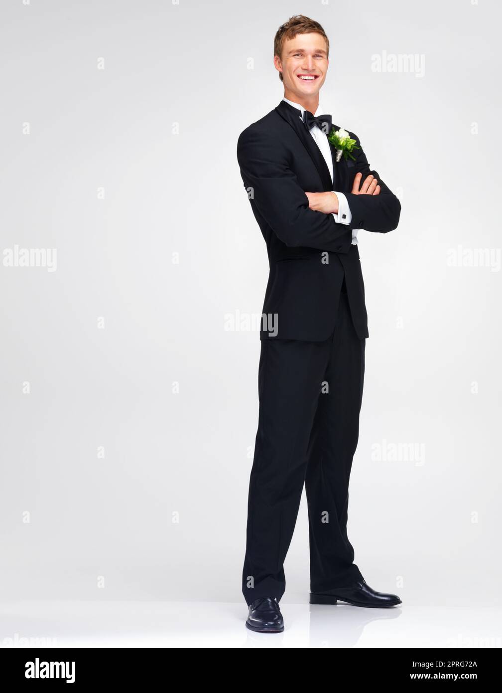 Mariage mariage et marie avec un beau homme debout bras croises en studio sur un fond blanc. Un homme heureux en costume ou en smoking avec un sourire pret a se marier