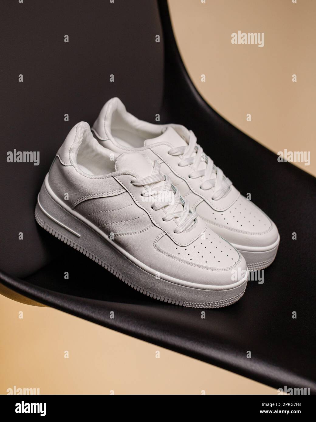 Gros plan sur des baskets blanches confortables et décontractées sur fond noir et beige. Banque D'Images Gros plan sur des baskets blanches confortables et décontractées sur fond noir et beige. Banque D'Images