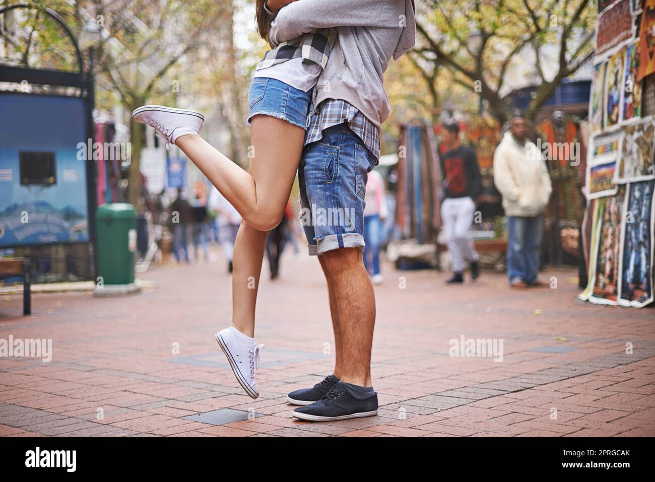 L'amour urbain. Taille basse coupe courte d'un couple affectueux avec la jeune fille qui lève l'une de ses jambes vers le haut. Banque D'Images