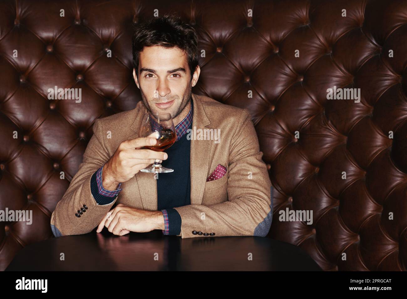 En attente de mes amis. Portrait d'un beau jeune homme qui boit dans un club. Banque D'Images