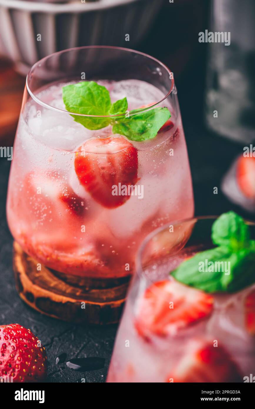 Verres de cocktail avec fraisier frais et congelé, gin et tonique Banque D'Images