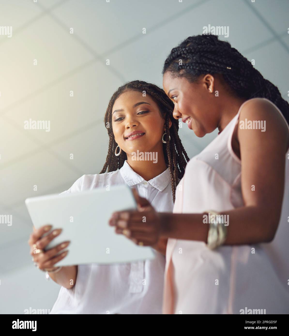 Faire un grand succès de leur petite entreprise. Jeunes partenaires d'affaires travaillant ensemble sur une tablette numérique. Banque D'Images