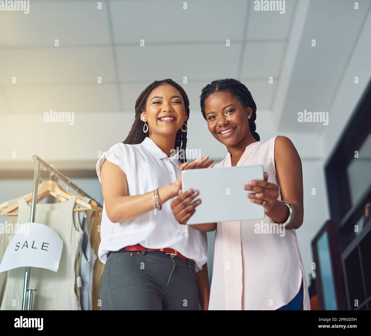 Faire un succès de leur entreprise. Portrait de jeunes partenaires d'affaires travaillant ensemble sur une tablette numérique. Banque D'Images