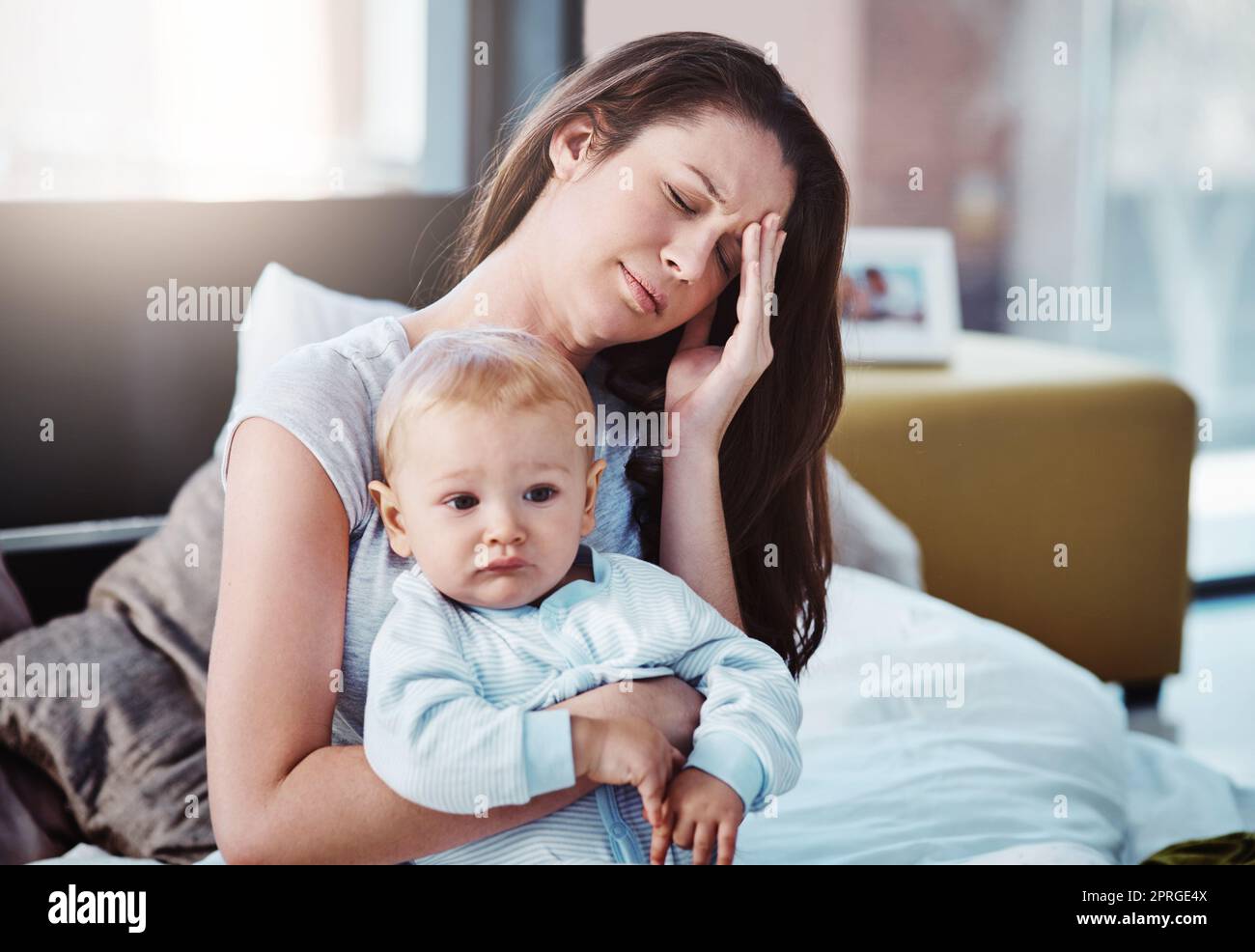 Mal de tête au mauvais moment. Une mère et son bébé garçon à la maison. Banque D'Images