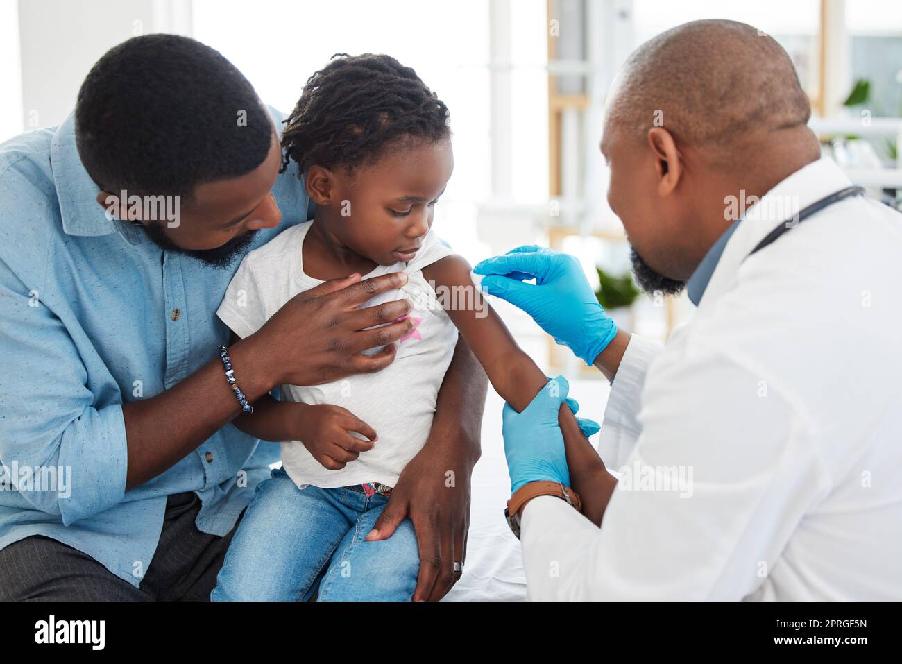 Covid, dengue et vaccin médical d'un enfant avec un père et un enfant médecin ou pédiatre. Un professionnel de la santé travaille et aide à l'injection de médicaments dans un hôpital familial, une clinique pour bébés ou un établissement de santé Banque D'Images
