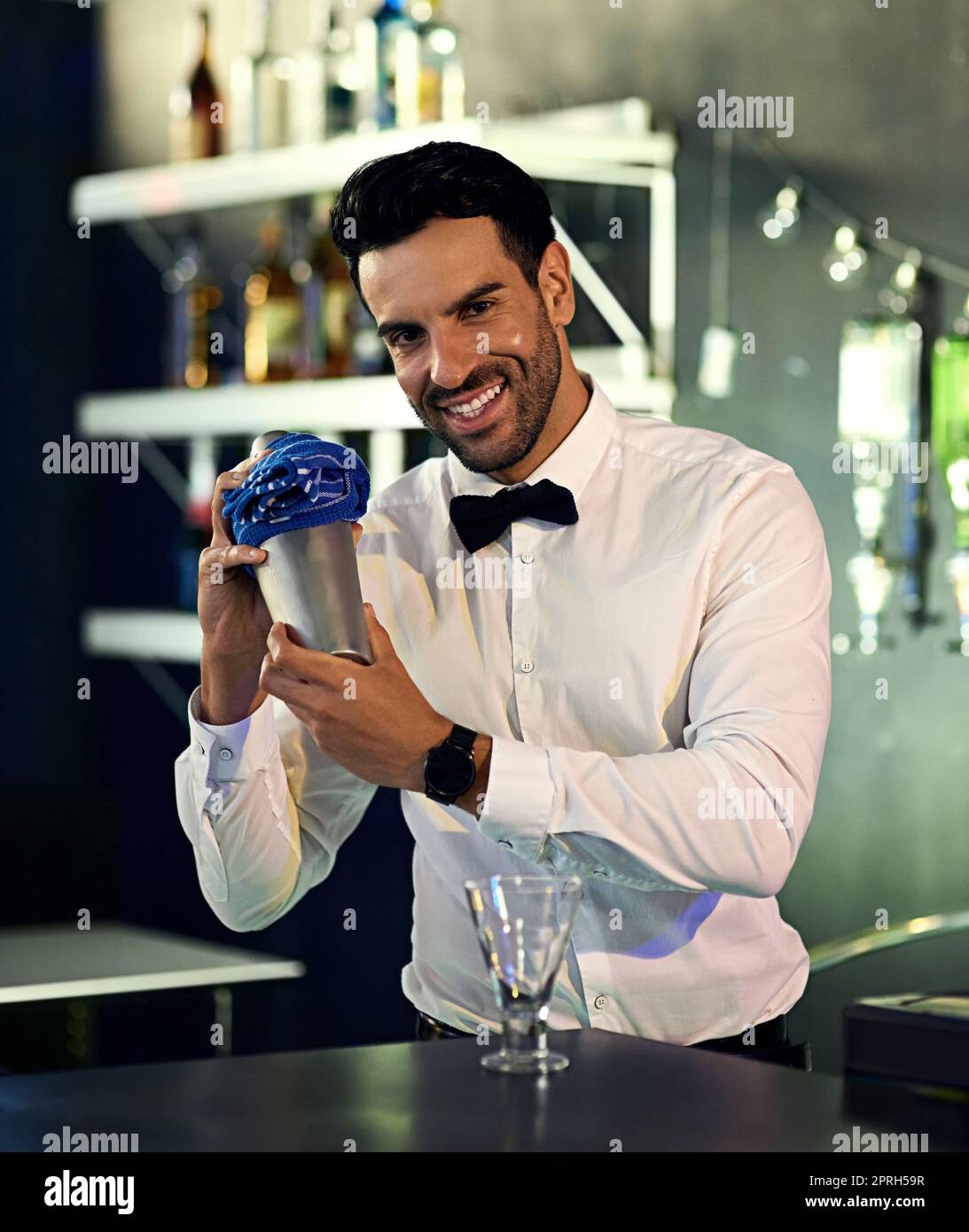 Il y a quelque chose de spécial à boire. Portrait d'un barman qui mélange des boissons derrière le bar dans une discothèque. Banque D'Images