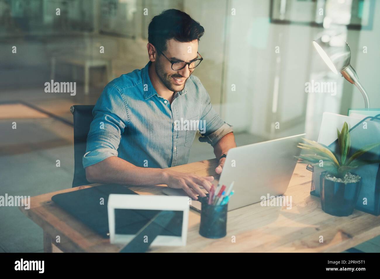 Travailler dur pour ceux de retour à la maison. Photo en grand angle d'un homme d'affaires travaillant sur son ordinateur portable au bureau. Banque D'Images