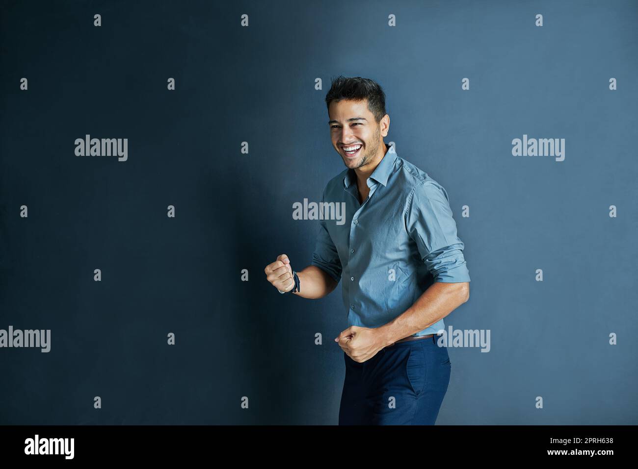 Il est très motivé aujourd'hui. Studio photo d'un jeune homme joyeux et motivé debout et poing pompe l'air dans le succès. Banque D'Images