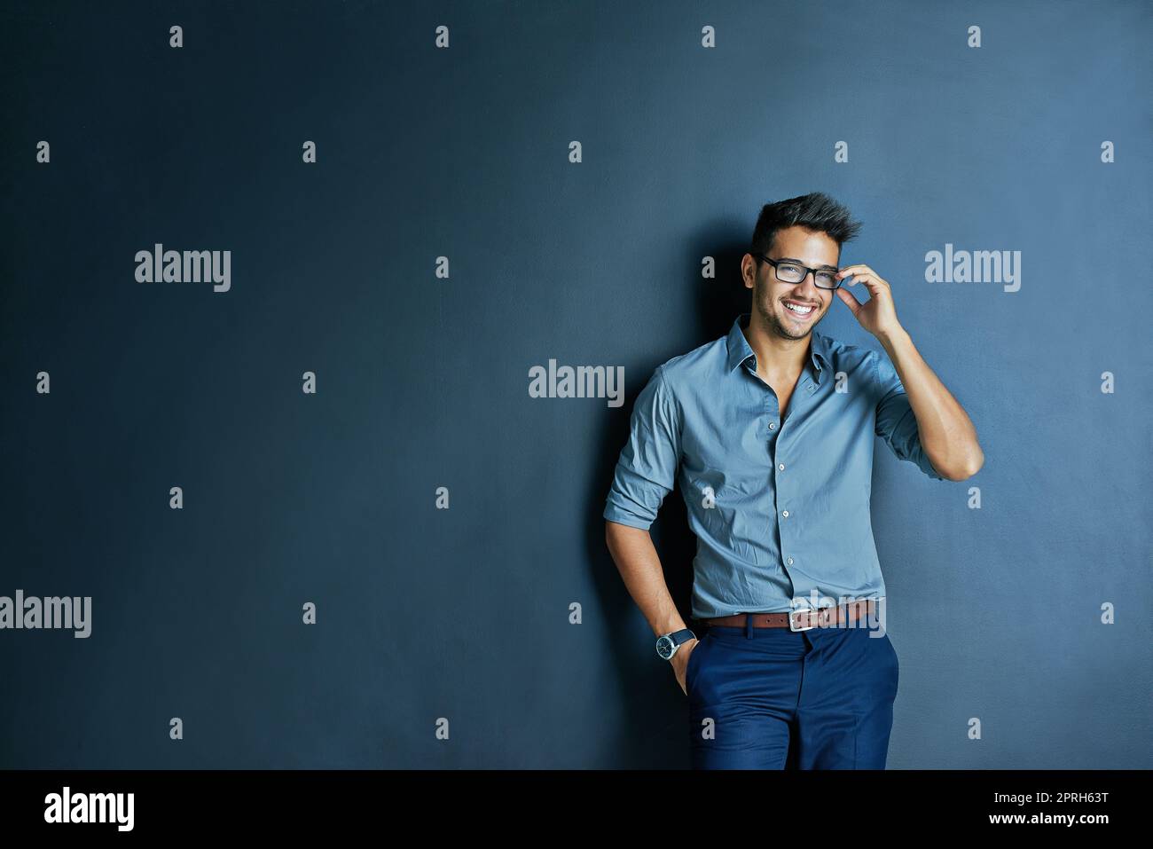 Il va À plus tard. Studio photo d'un jeune homme joyeux avec des lunettes debout avec une main dans sa poche tout en regardant l'appareil photo. Banque D'Images