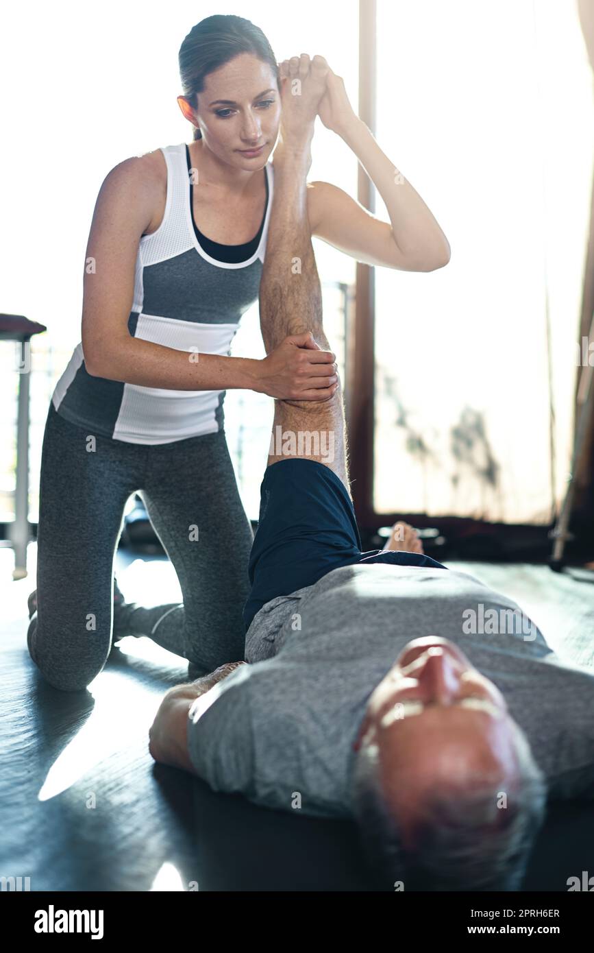 Avec l'exercice, les années d'or continuent à s'améliorer. Un homme senior travaillant avec son physiothérapeute. Banque D'Images