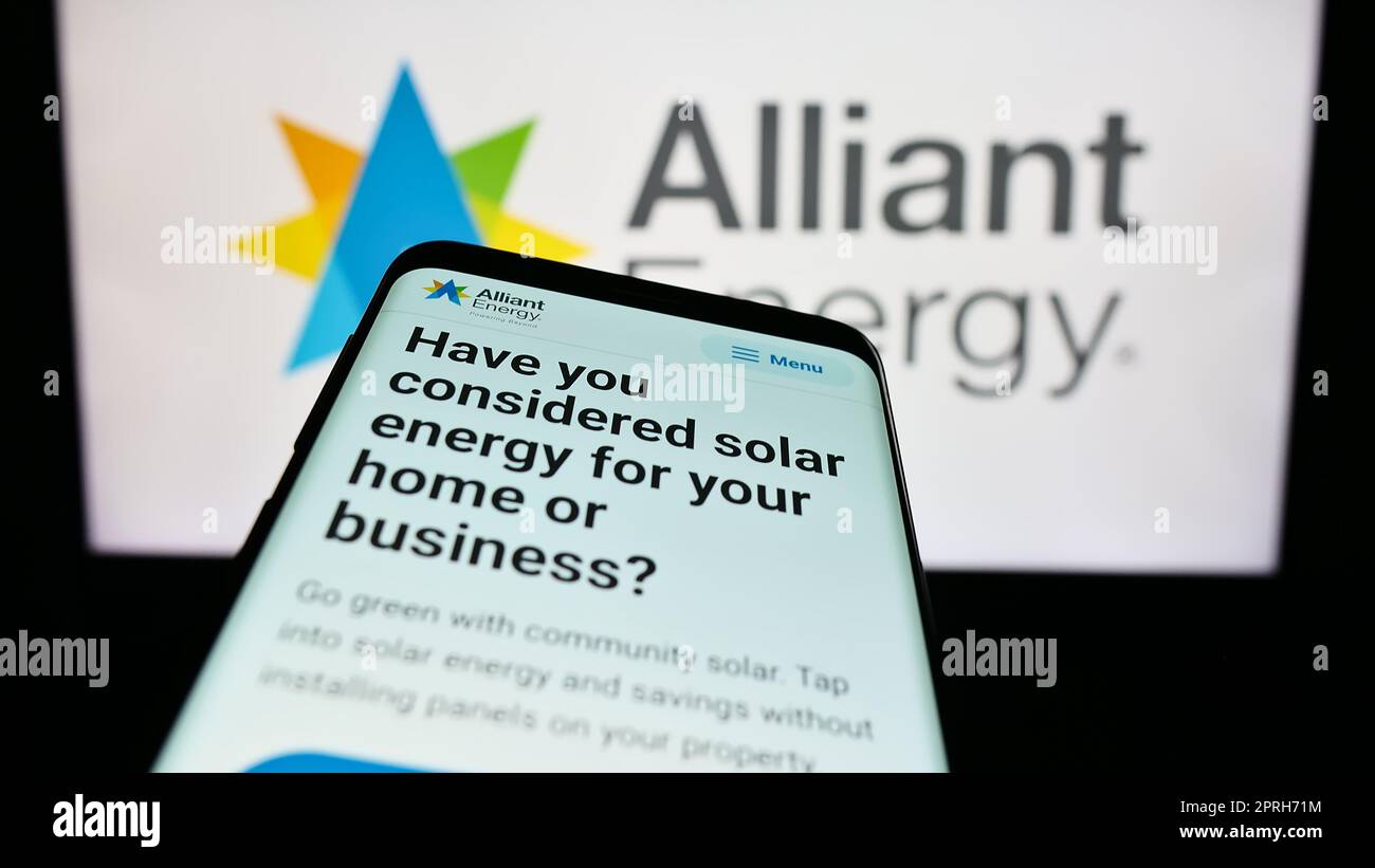 Smartphone avec le site Web de la société américaine alliant Energy Corporation à l'écran devant le logo de l'entreprise. Faites la mise au point dans le coin supérieur gauche de l'écran du téléphone. Banque D'Images