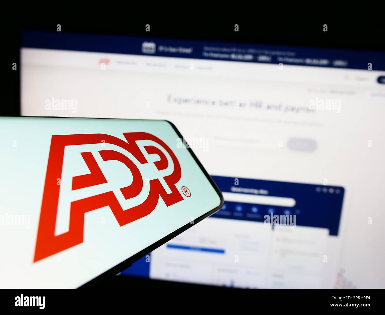 Smartphone avec le logo de la société américaine Automatic Data Processing Inc (ADP) à l'écran en face du site Web. Effectuez la mise au point au centre-droit de l'écran du téléphone. Banque D'Images