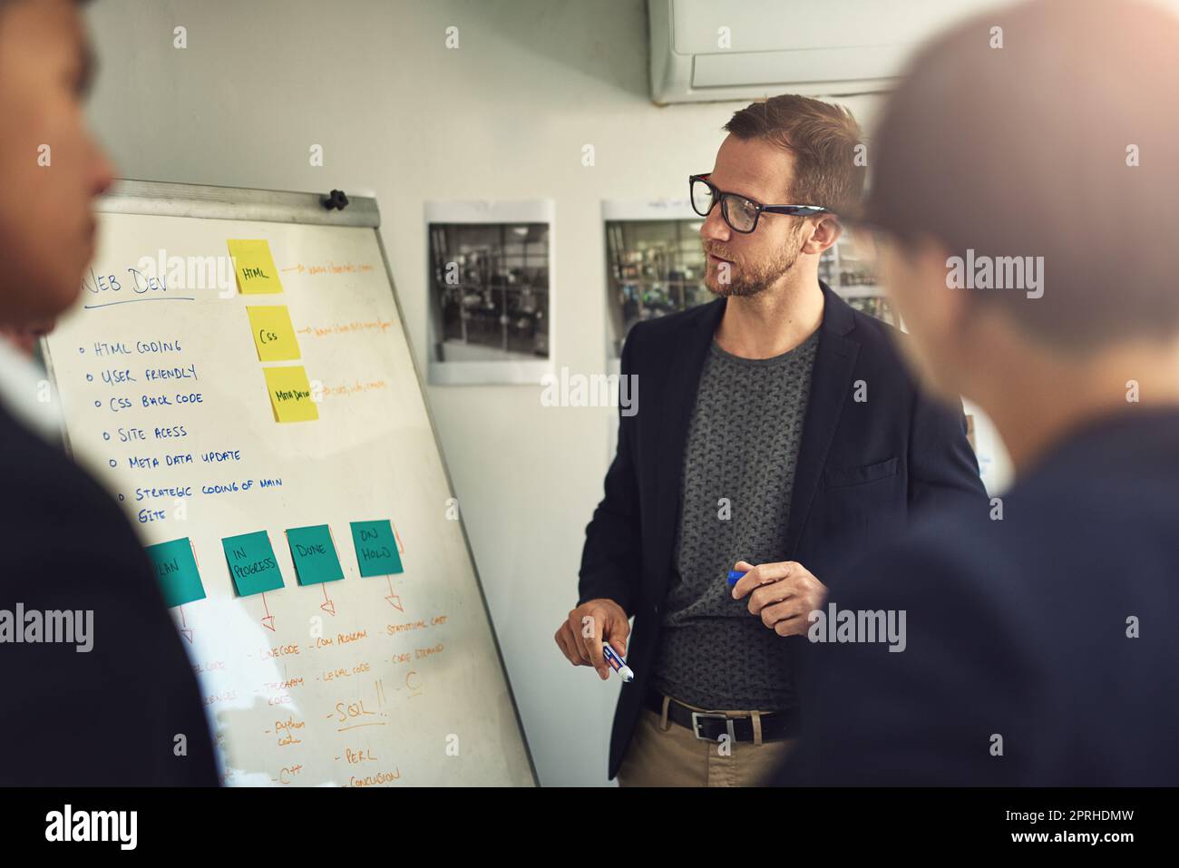 Parler de l'équipe par sa proposition. Un jeune homme qui donne une présentation à des collègues dans un bureau. Banque D'Images