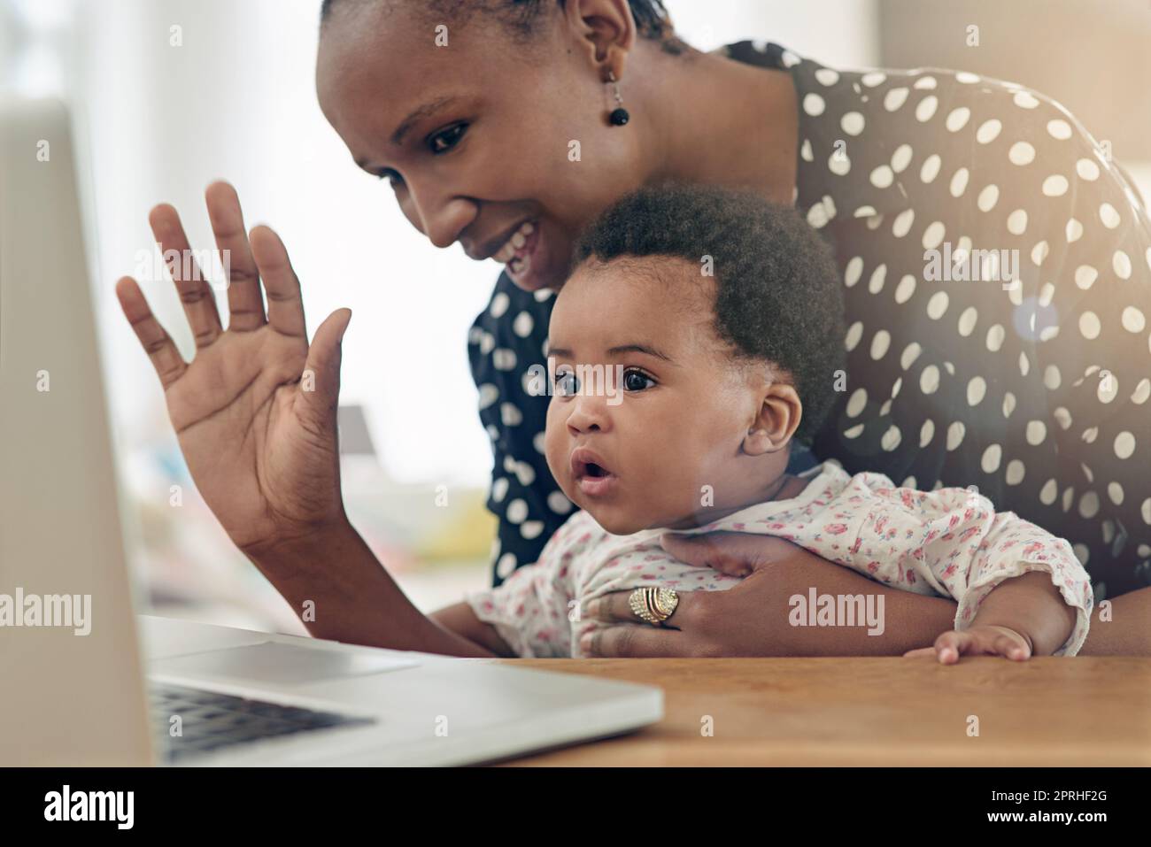 Une mère et sa petite fille sont assises devant un ordinateur portable. Banque D'Images