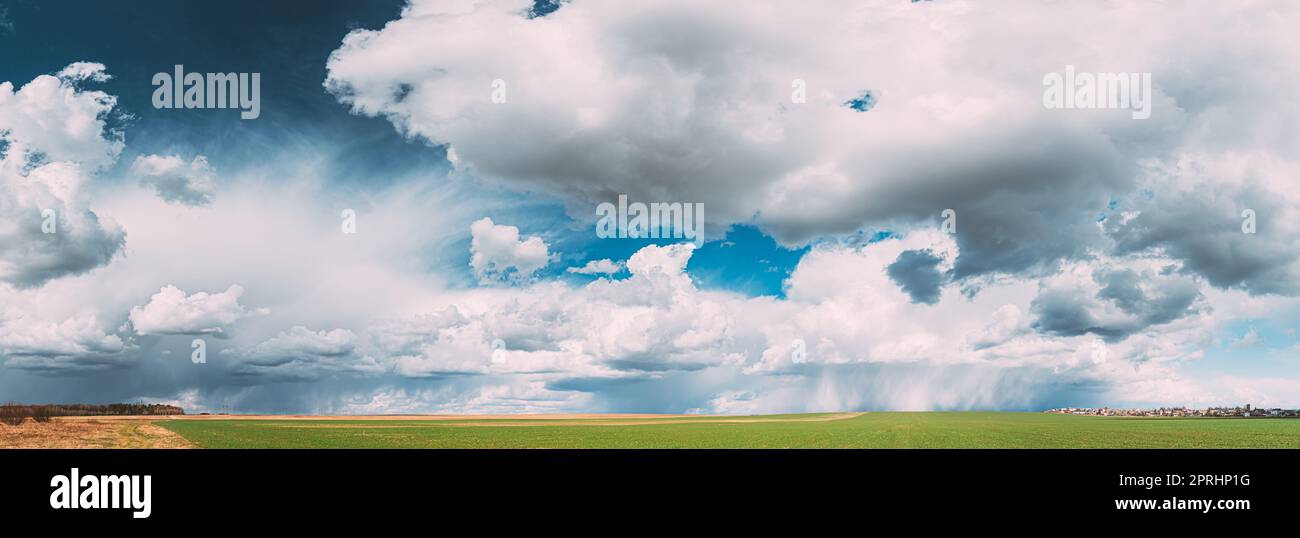 Campagne rurale Field Meadow Paysage dans Sunny Rainy Spring Day. Ciel pittoresque avec nuages de pluie sur Horizon. Concept de prévision agricole et météorologique. Panorama Banque D'Images