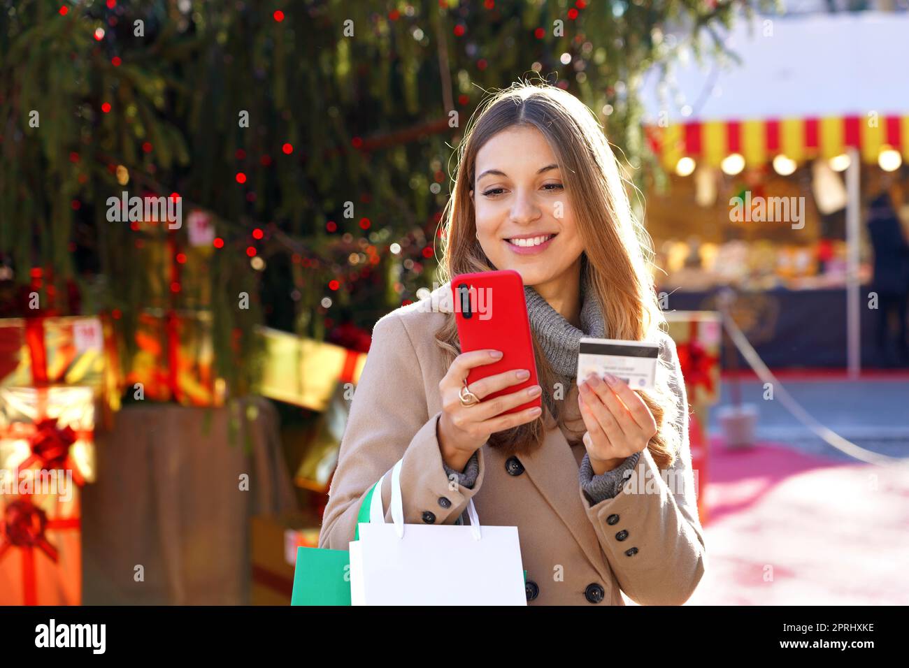 Femme de Noël portant des sacs d'achats à l'extérieur. Belle fille