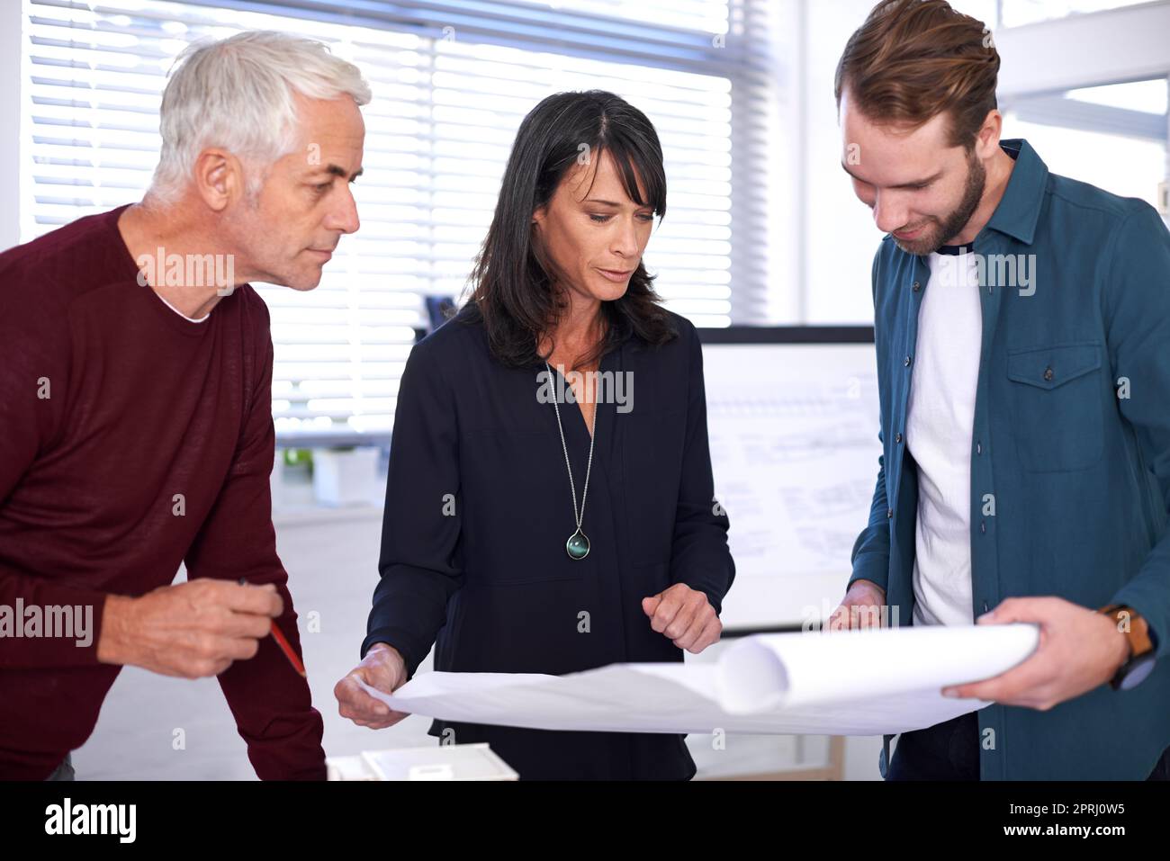 Ce sont mes idées. Un groupe d'architectes discutant des plans de construction au bureau Banque D'Images